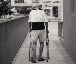 Old man with lumbar support and walking frame